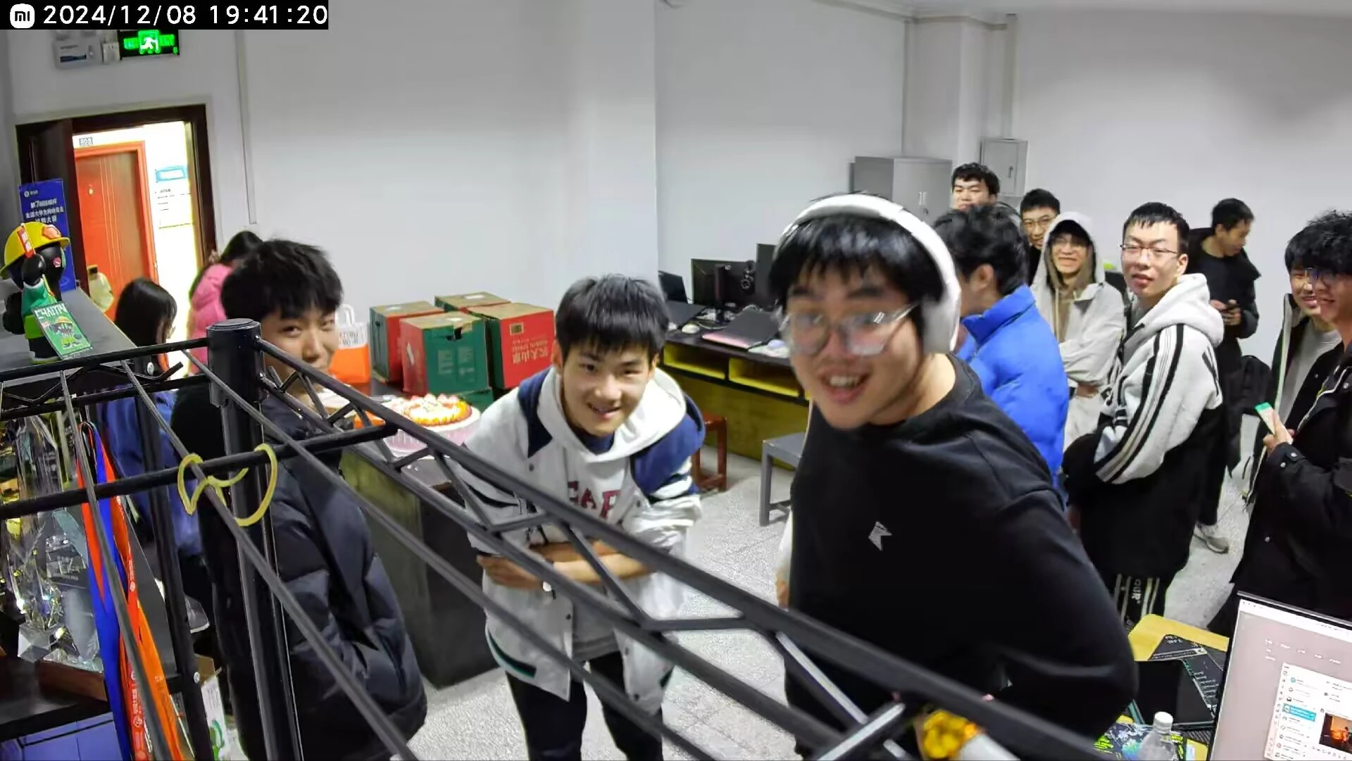 队员在摆有电脑和蛋糕的工作室里相聚