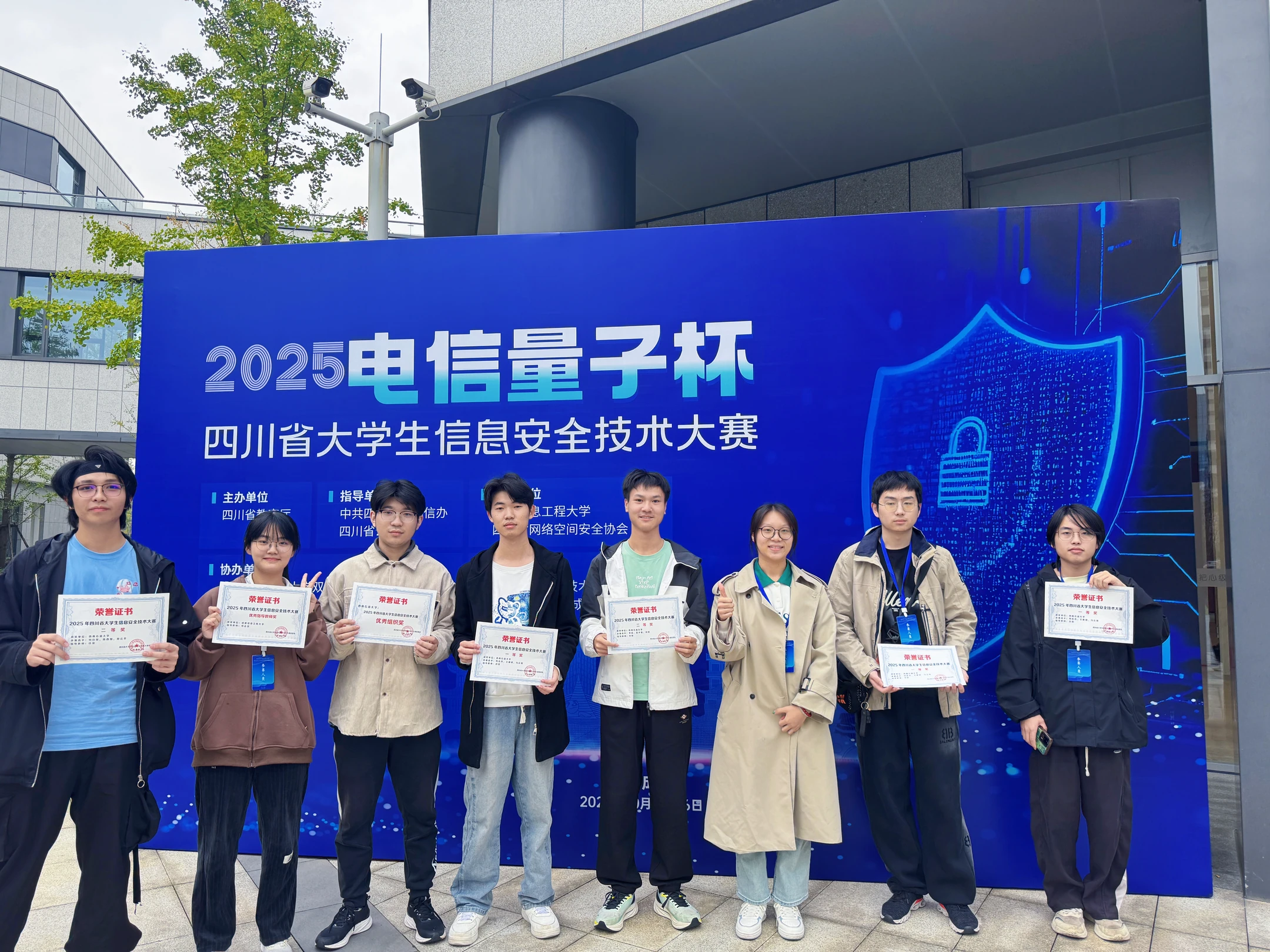 八位队员手持证书，在2025电信量子杯四川省大学生信息安全技术大赛背景板前合影