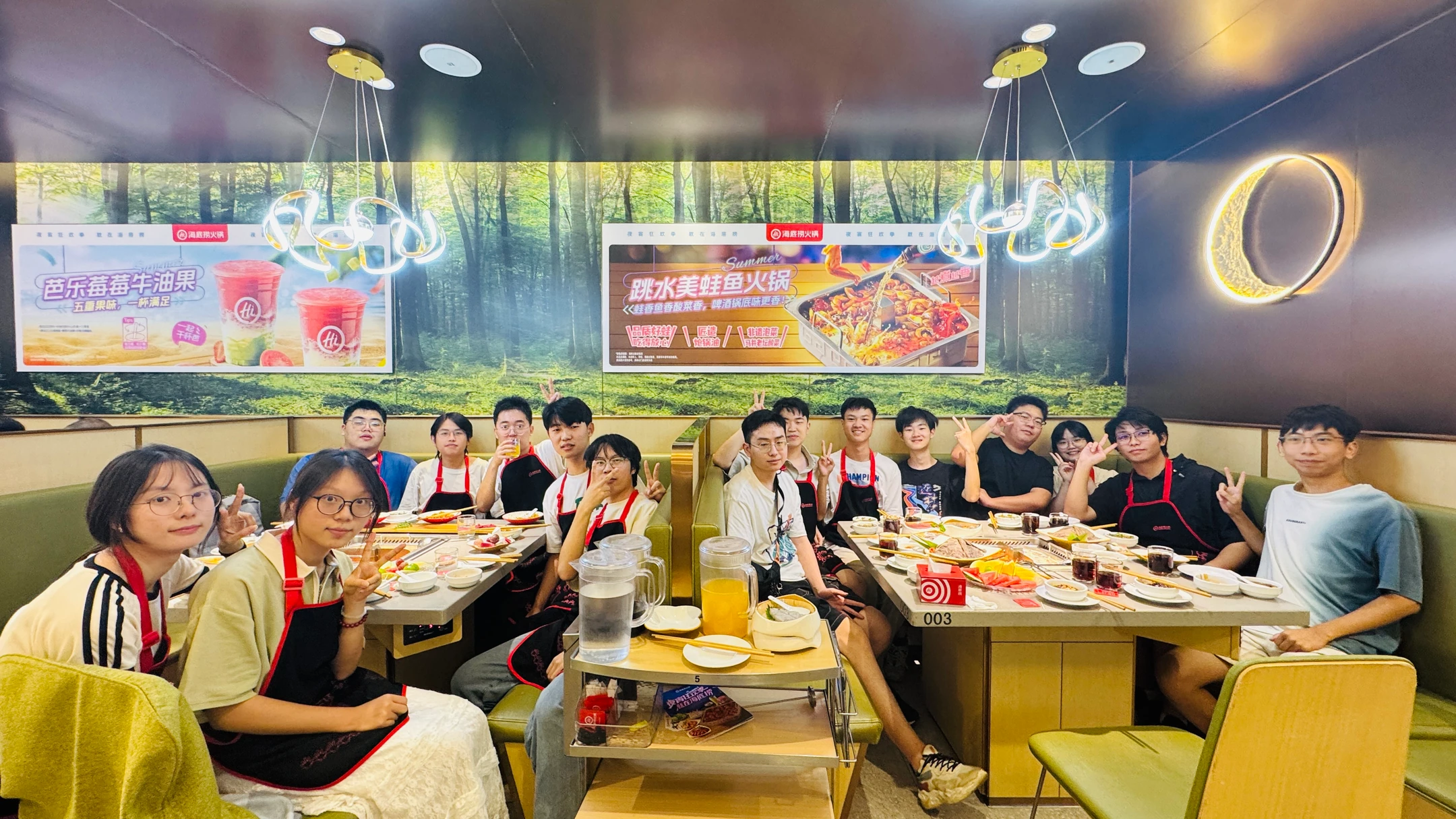 队员们围坐在餐桌旁，一起举手合影