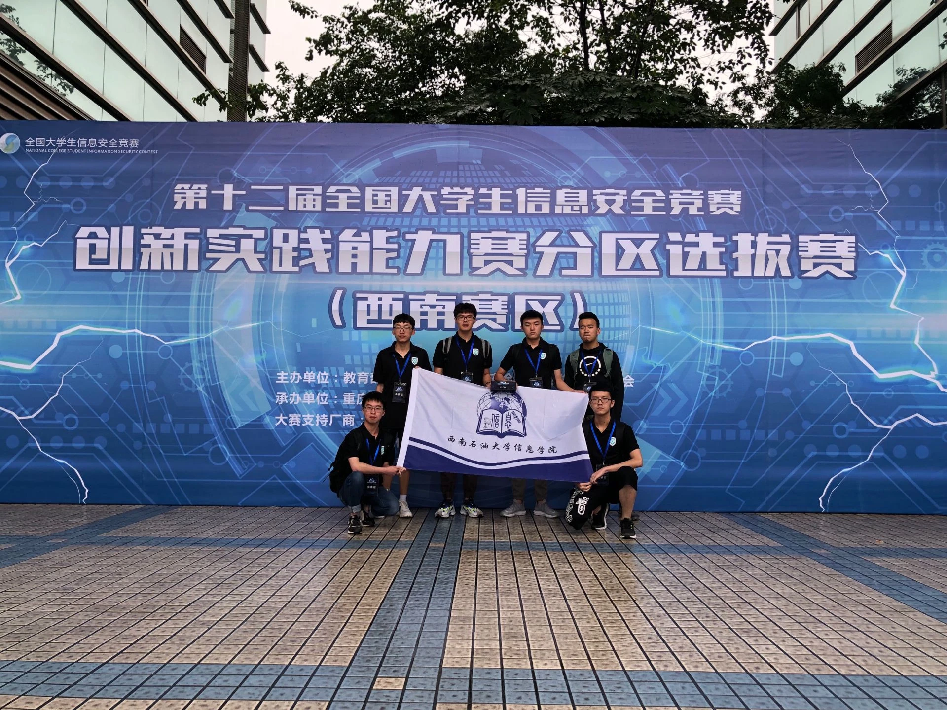 2019 年西南赛区，六位队员与西南石油大学信息学院旗帜合影